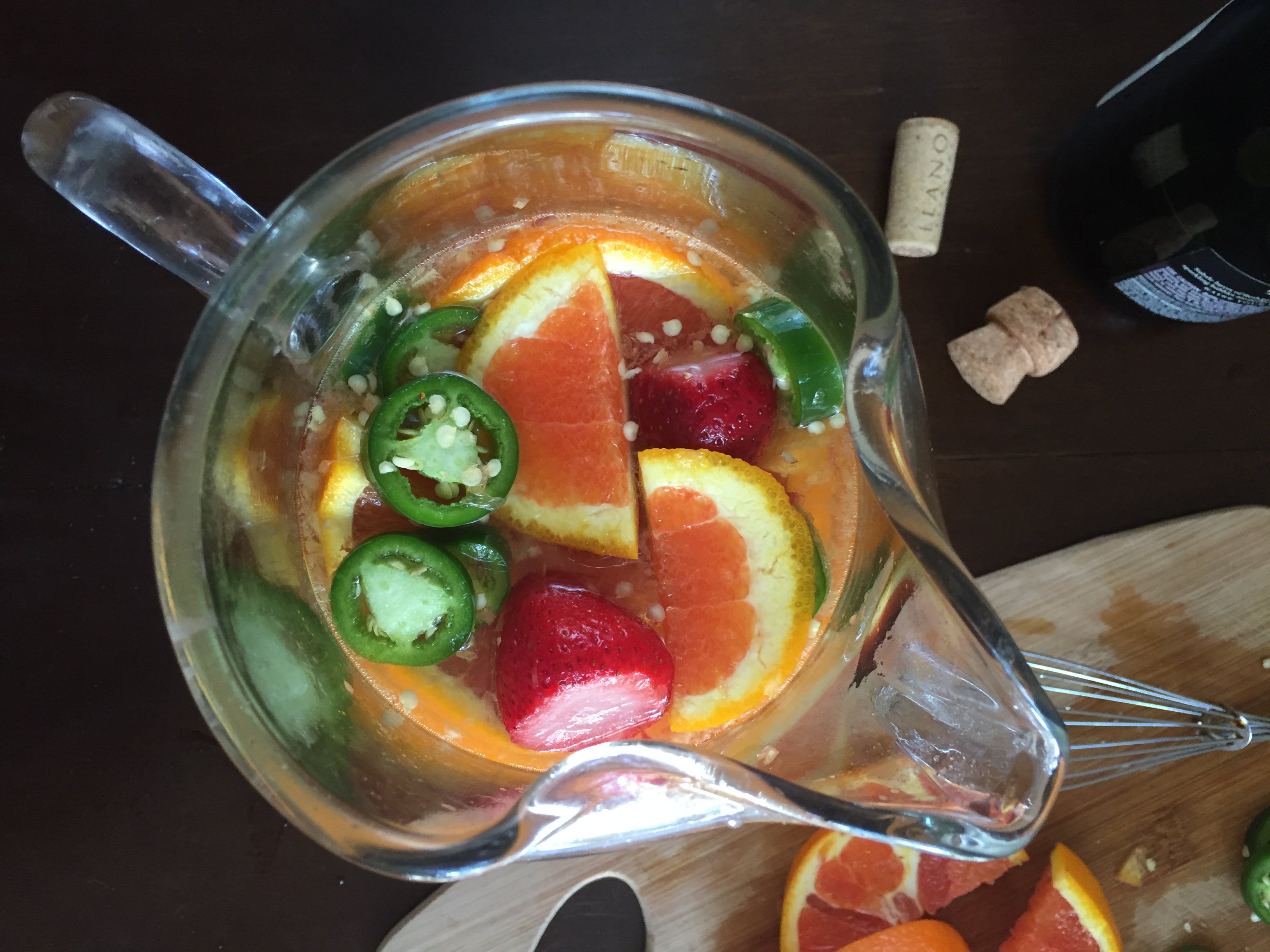 A sweet & spicy sangria made with cara cara oranges, jalapeno, strawberries, peaches, sweet white wine, and champagne--perfect for a summer get-together! Recipe by Dash of Jazz